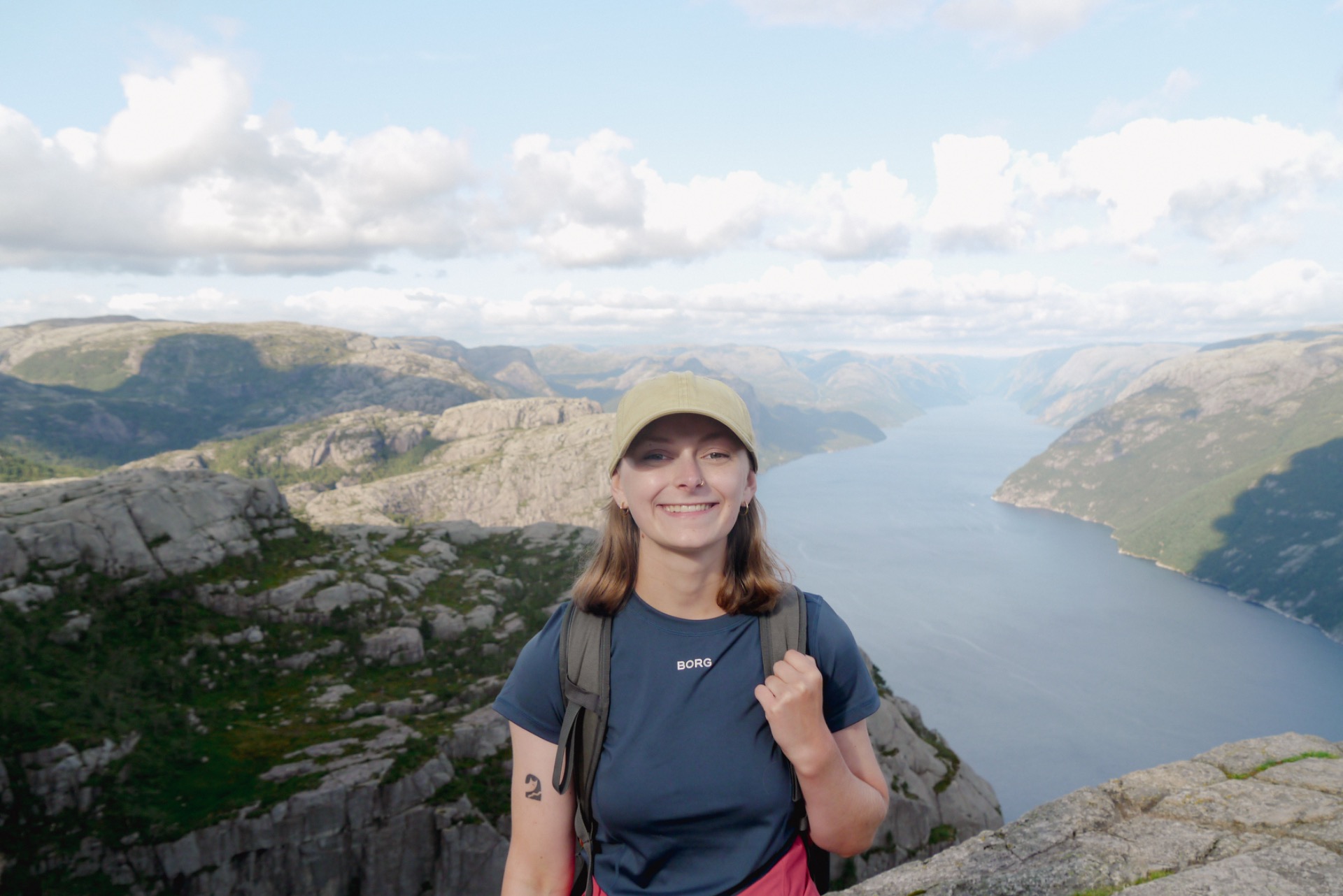 Fleur, de schrijver van de blog, poseert in Noorwegen met een uitzicht op de fjorden